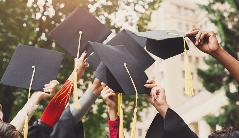 A group of graduates throwing graduation caps in the air